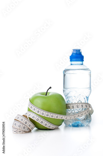 Green apple and bottle water with measuring tape
