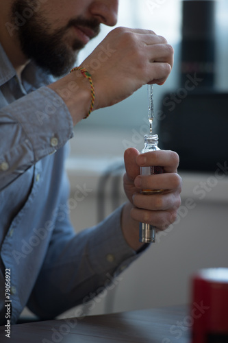 Businessman filling electronic cigarette with liquid