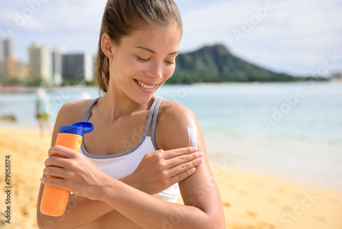Sunscreen fitness woman applying suntan lotion