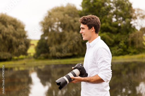 young male photographer with dslr camera outdoors