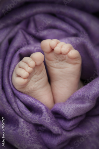 baby feet wrapped with a soft cloth © iskandarov