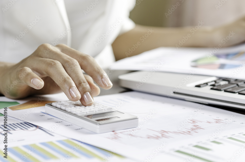 Woman using a calculator in office Woman using a calculator in office