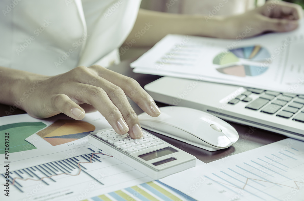 Woman using a calculator in office Woman using a calculator in office
