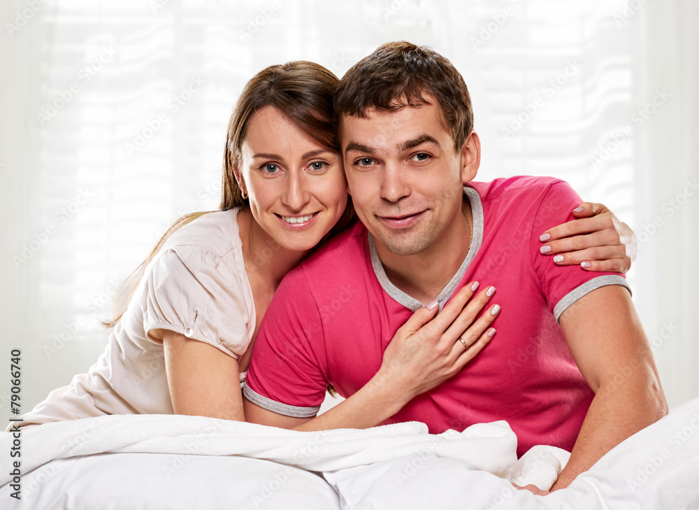 Couple lying in bed smiling