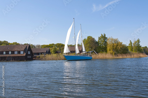 Boathouses and a sailing ship on the Mueritz Lake