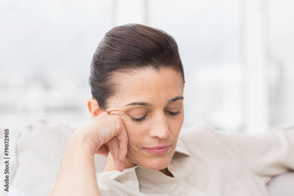Woman relaxing with eyes closed on sofa Woman relaxing with eyes closed on sofa