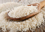 Uncooked rice in a wooden  spoon