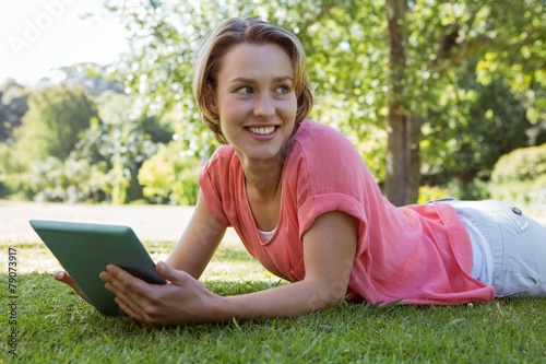 Pretty woman using tablet in park