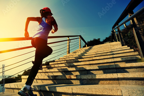 young fitness woman running on seaside stone stairs photo