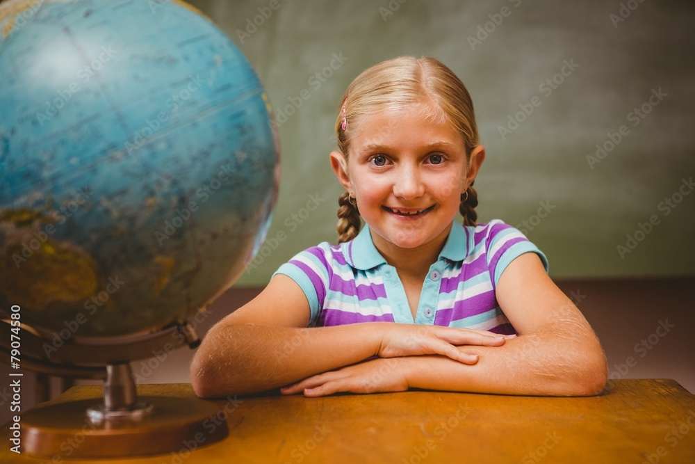 Portrait of cute little girl sitting at desk Stock Photo | Adobe Stock