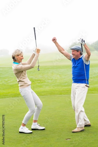 Cheering golfing couple
