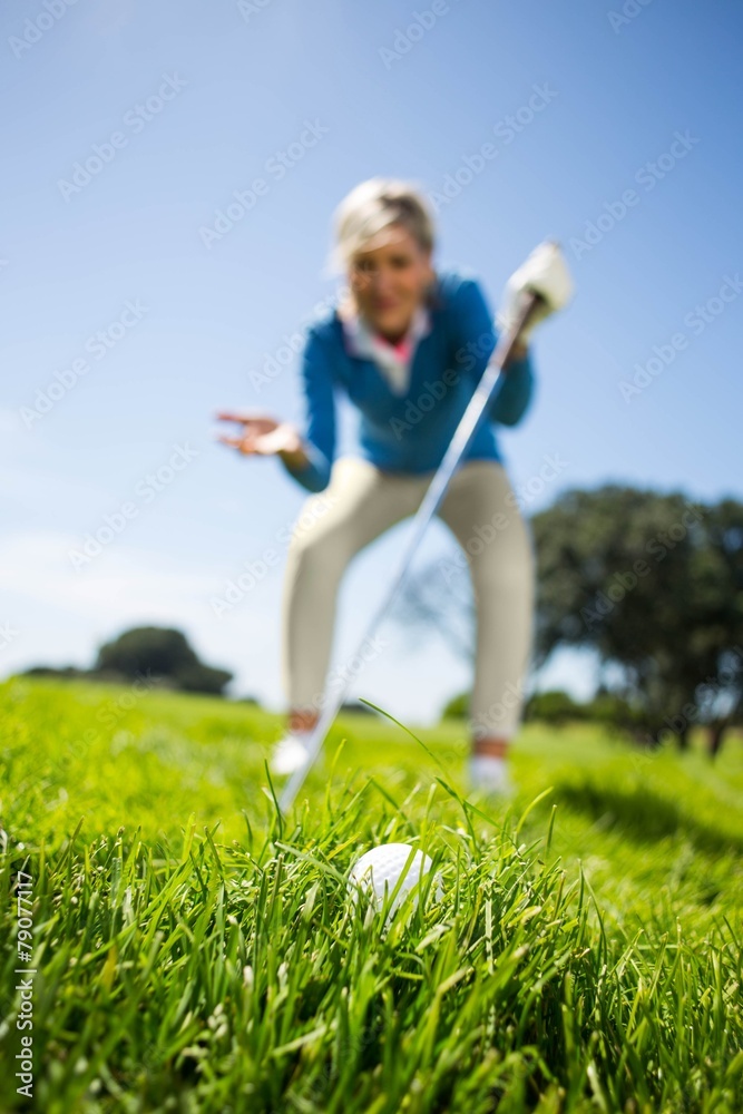 Worried female golfer looking at golf ball Worried female golfer looking at golf ball