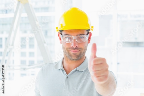 Manual worker gesturing thumbs up at site