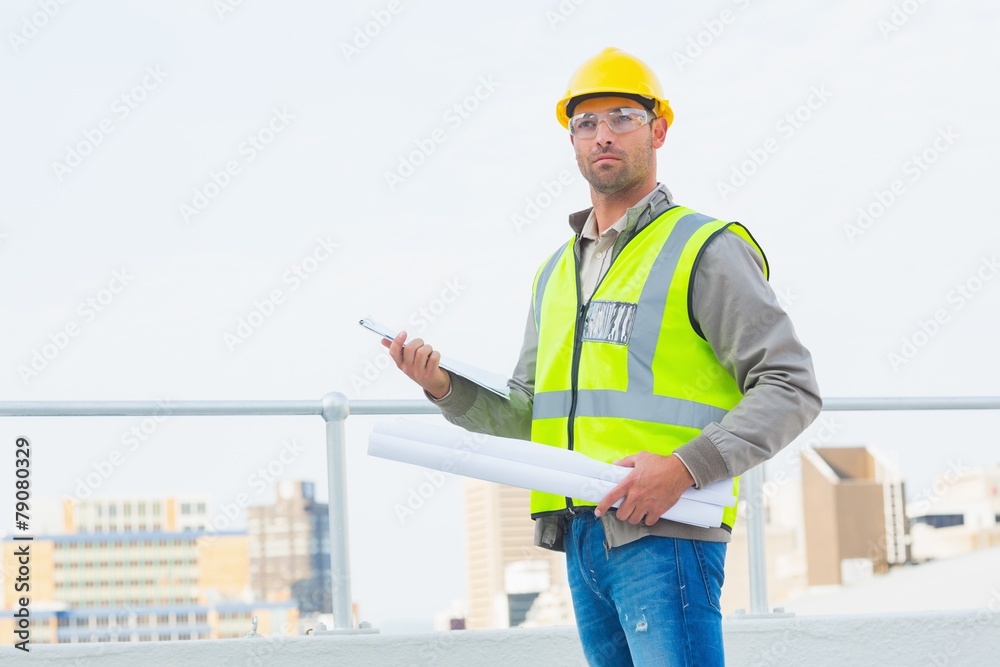 Architect holding blueprints and clipboard outdoors Architect holding blueprints and clipboard outdoors