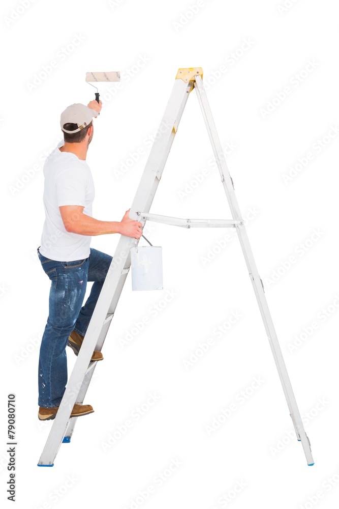 Handyman climbing ladder while using paint roller Handyman climbing ladder while using paint roller