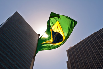 Fototapete Brasilien Brasiliens Flagge vor Skyline im Sonnenuntergang  © Donatas Dabravolskas
