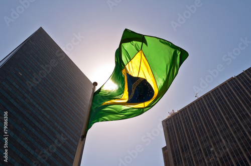 Brazilian National Flag against Skyscrapers by Sunset photo