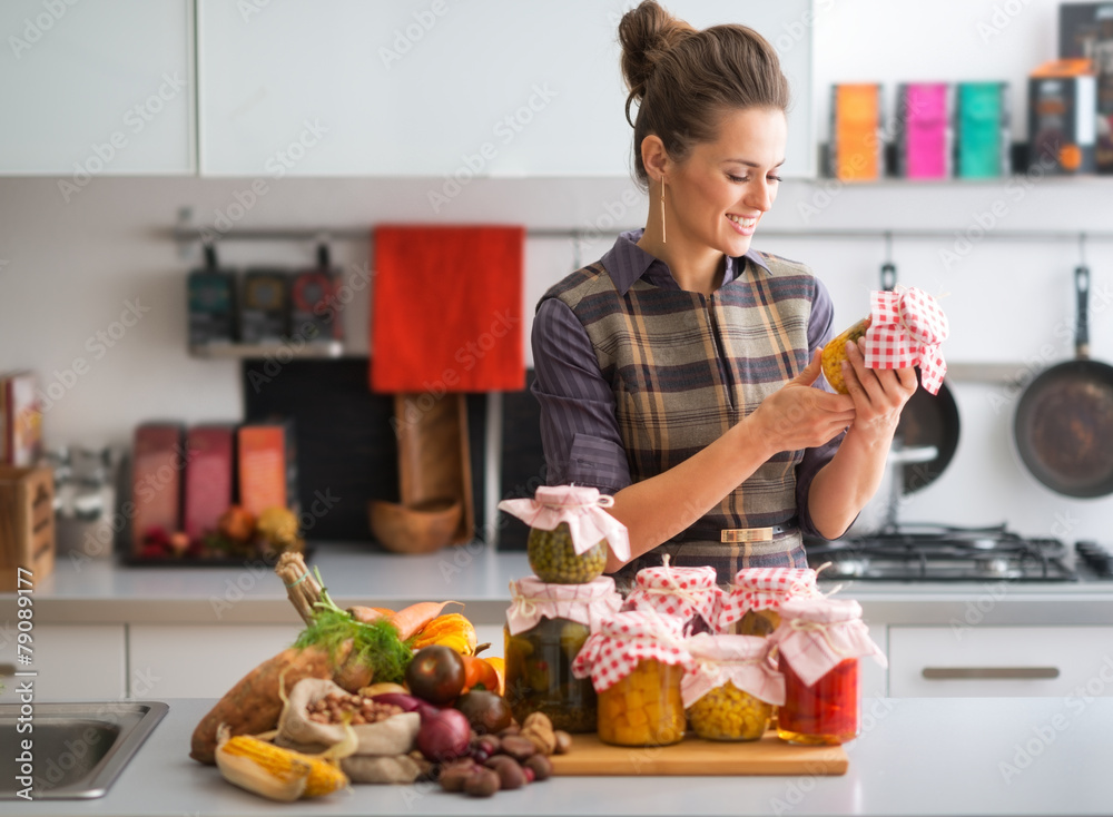 Happy young housewife with jars of pickled vegetables Happy young housewife with jars of pickled vegetables