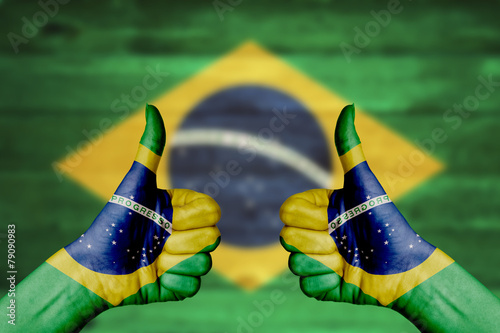 Brazil flag painted on female hands thumbs up #79090983