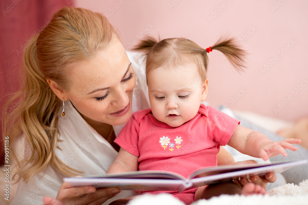 happy mother reads a book to baby girl happy mother reads a book to baby girl