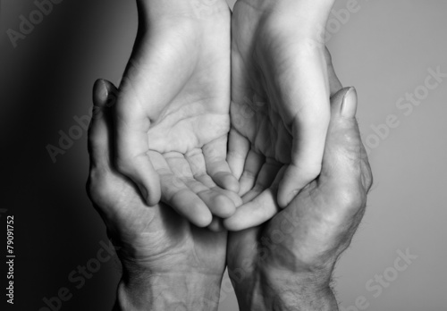 Hands of the old and the young man. Black and white. top view