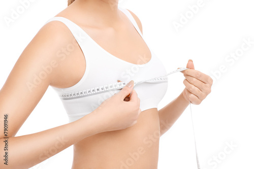 Fit woman measuring her breast