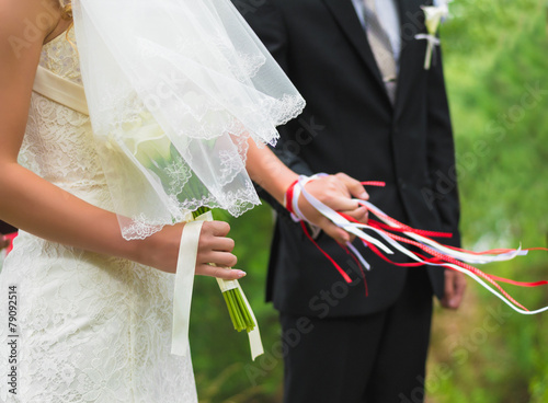 Hands newlyweds tied with a ribbon photo