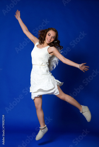 Angel girl in motion on a blue background. ecological concept