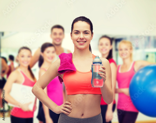 sporty woman with towel and water bottle