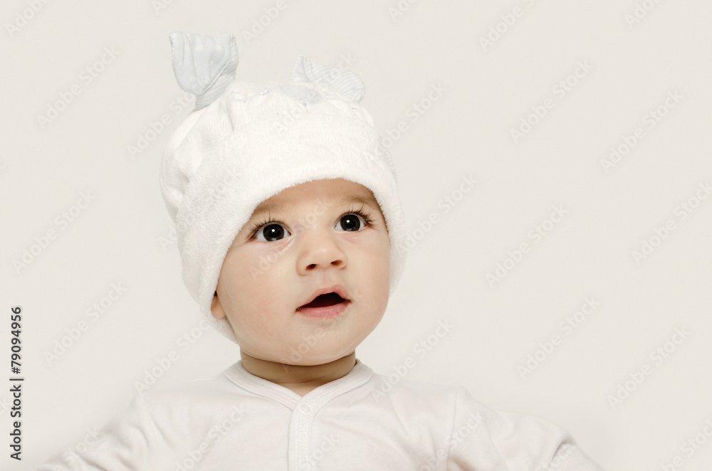 Innocent baby wearing a white bunny hat looking adorable. Innocent baby wearing a white bunny hat looking adorable.