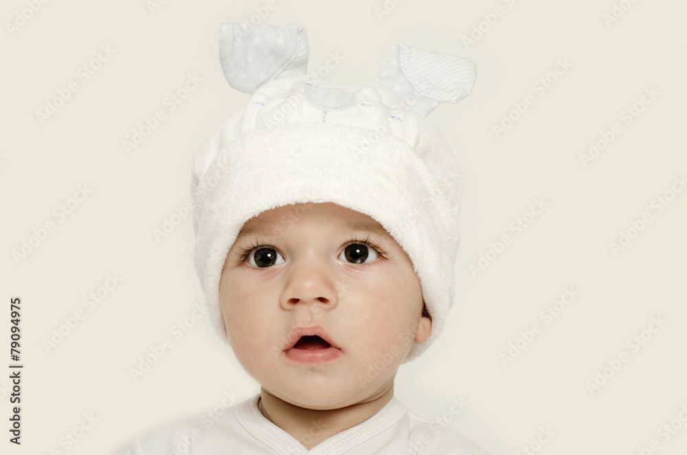 Innocent baby wearing a white bunny hat looking adorable. Innocent baby wearing a white bunny hat looking adorable.
