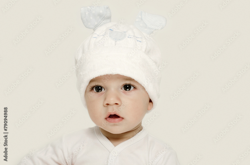 Innocent baby wearing a white bunny hat looking adorable. Innocent baby wearing a white bunny hat looking adorable.