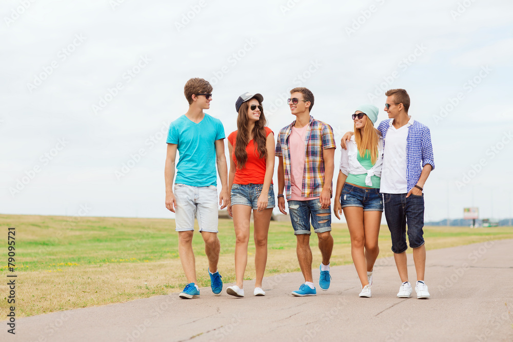 group of smiling teenagers walking outdoors
