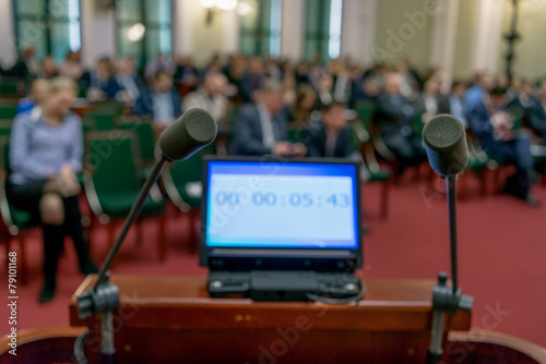 screen with time and two microphones in a conference room