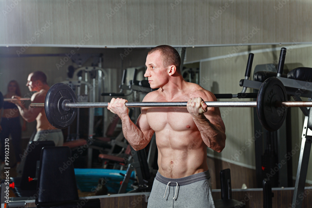 Man practicing with barbell in gym Man practicing with barbell in gym