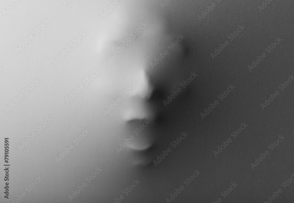 Screaming human face pressing through fabric as horror Screaming human face pressing through fabric as horror