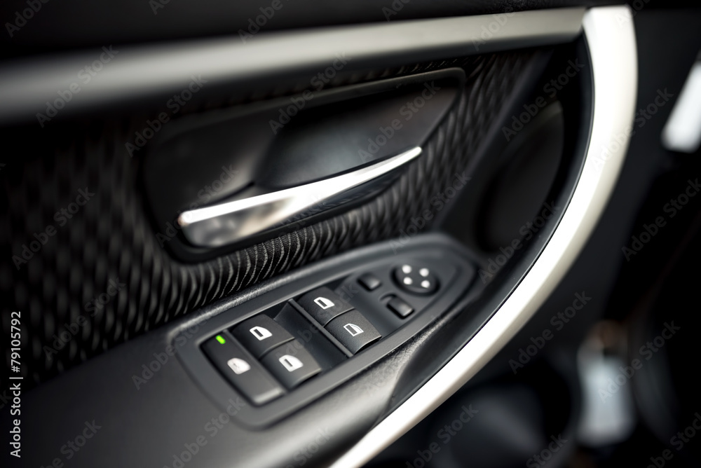 car interior details of door handle with windows controls