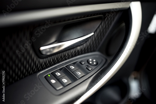 car interior details of door handle with windows controls
