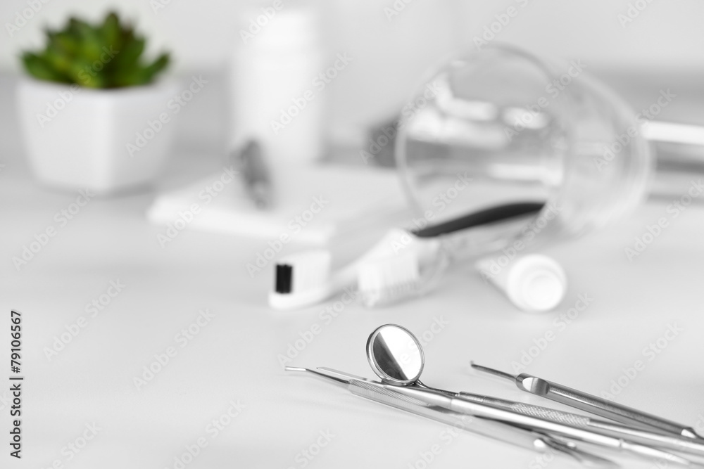 Dentist tools with toothpaste and brushes on table close up Dentist tools with toothpaste and brushes on table close up