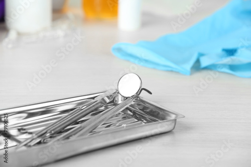 Dentist tools in metal tray on table close up