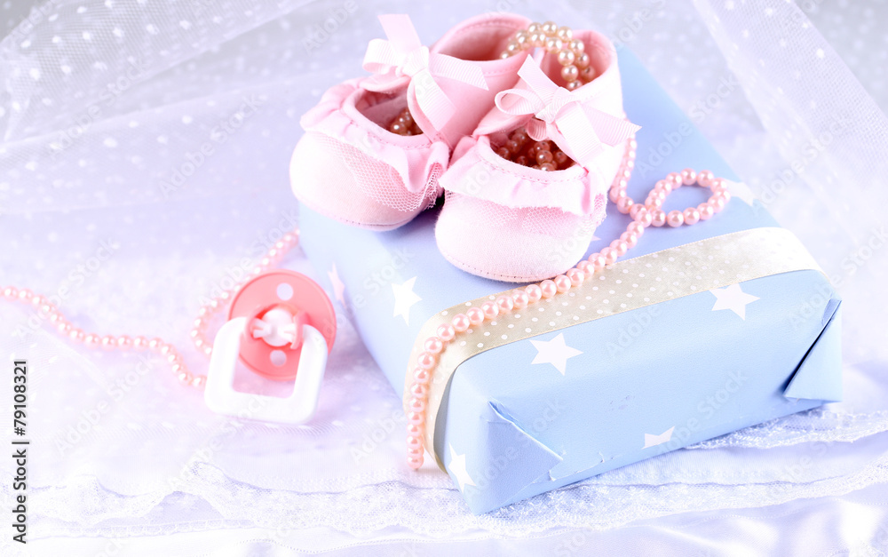 Pink baby boots with gift close-up Pink baby boots with gift close-up