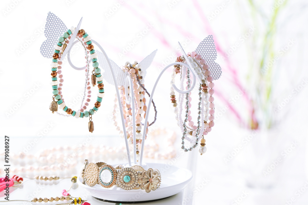 Fototapeta premium Decorative stand with jewelry and bijouterie on table in room