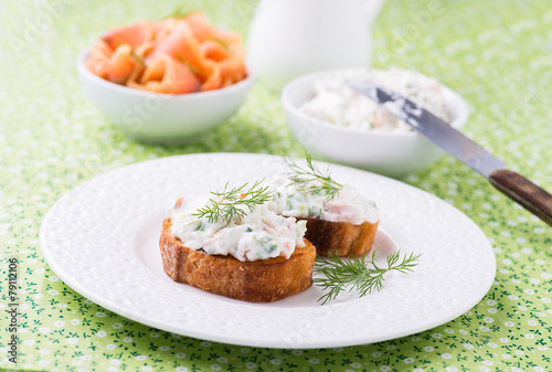 Canape with soft cheese spread on white plate
