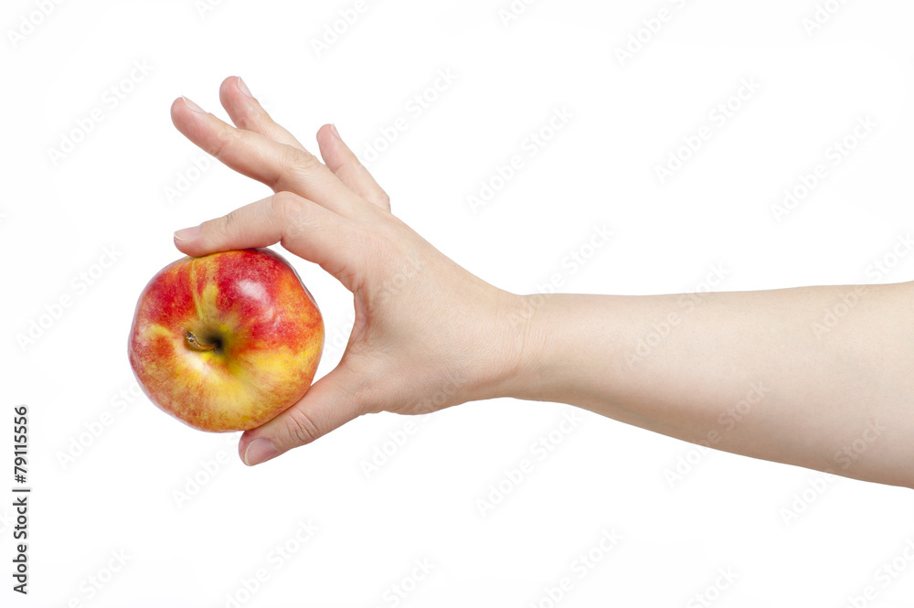 Female hand holding an apple with two fingers. In isolation.. Female hand holding an apple with two fingers. In isolation..