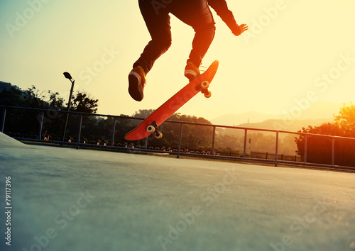 skateboarder jumping on sunrise skatepark