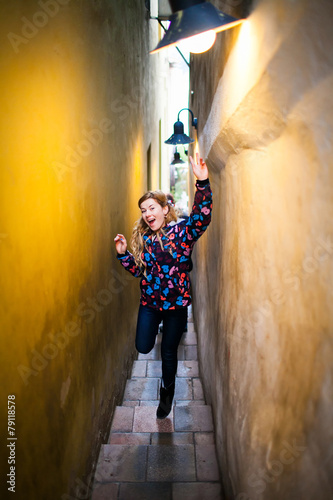 happy young woman at the narrowest street in Prague