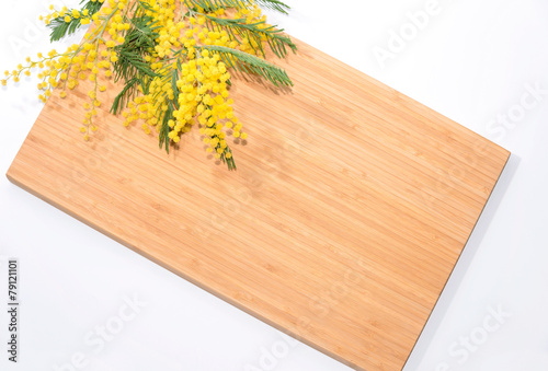 Branch of mimosa on a bamboo table