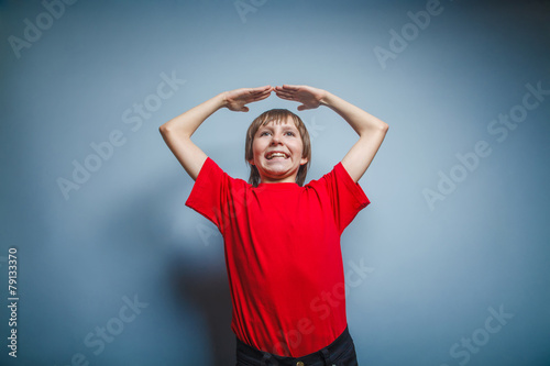 European-looking boy of ten years hands above his head, a gestur © maxximmm