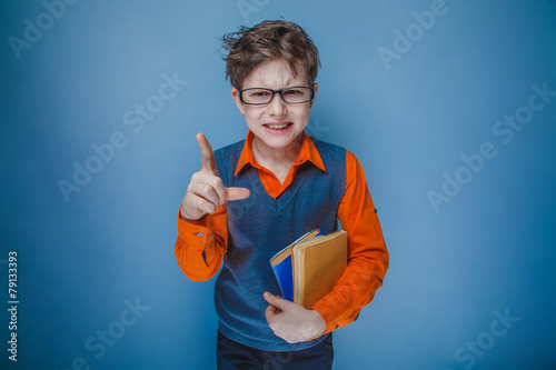 European-looking boy of ten years in glasses with a book showin