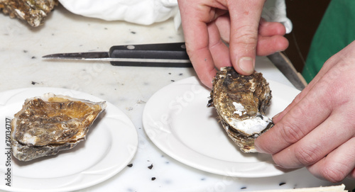 Chef is opening fresh oyster, close-up